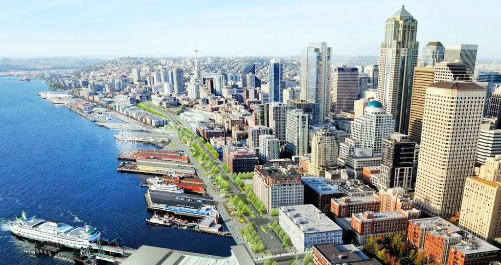 Daytime view of Seattle, Washington, with the iconic Space Needle, a skyline of skyscrapers, and Mount Rainier in the background under a clear blue sky