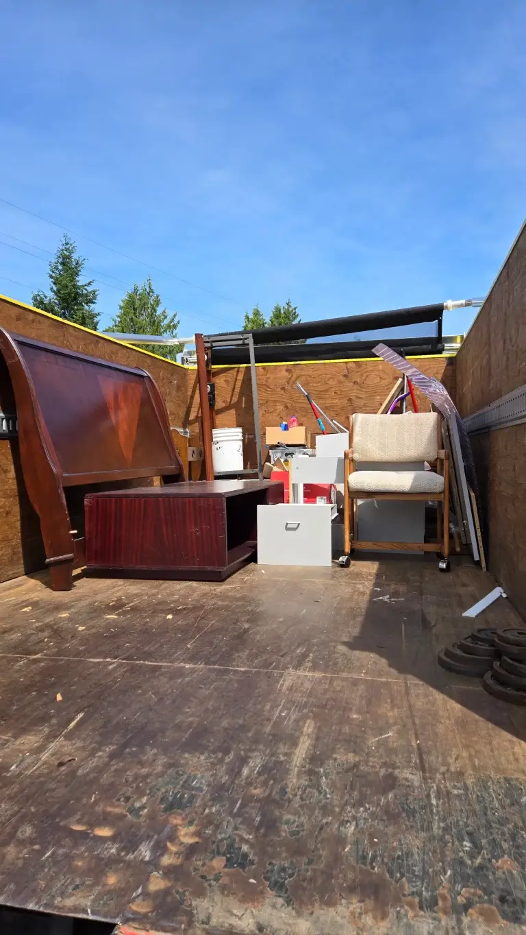 A truck filled with disassembled furniture and other household items during a mobile home cleanout.