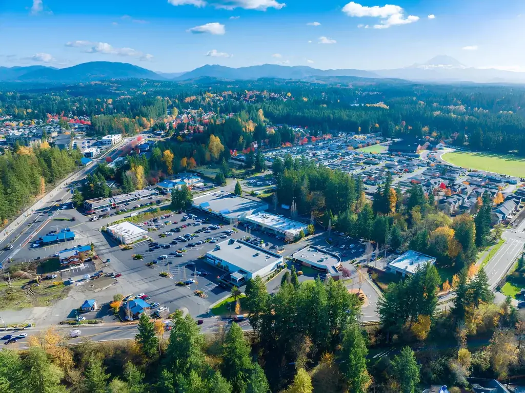 A vibrant aerial view of Maple Valley, WA, showcasing the town's commercial areas, residential neighborhoods, and scenic mountain backdrop, perfect for Junk Removal in Maple Valley WA.
