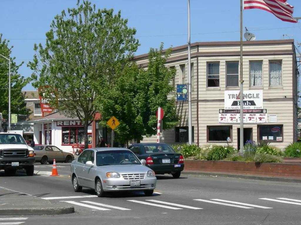 Street view of White Center, Seattle, WA, with local businesses, vehicles, and pedestrian activity. Junk Removal in White Center, WA services available.